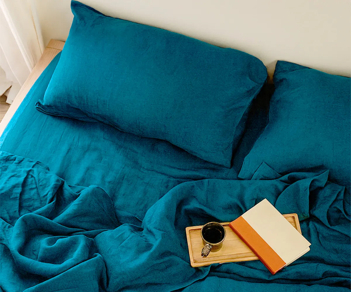 Luxurious teal linen bedding set with a smooth, breathable texture, neatly layered on a bed to create a cozy, stylish, and modern bedroom look.