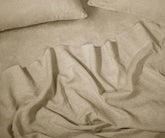 Beige linen sheet set made from 100% European linen sheets, displayed on a neatly made bed in a minimalist bedroom setting.