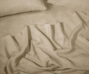 Beige linen sheet set made from 100% European linen sheets, displayed on a neatly made bed in a minimalist bedroom setting.