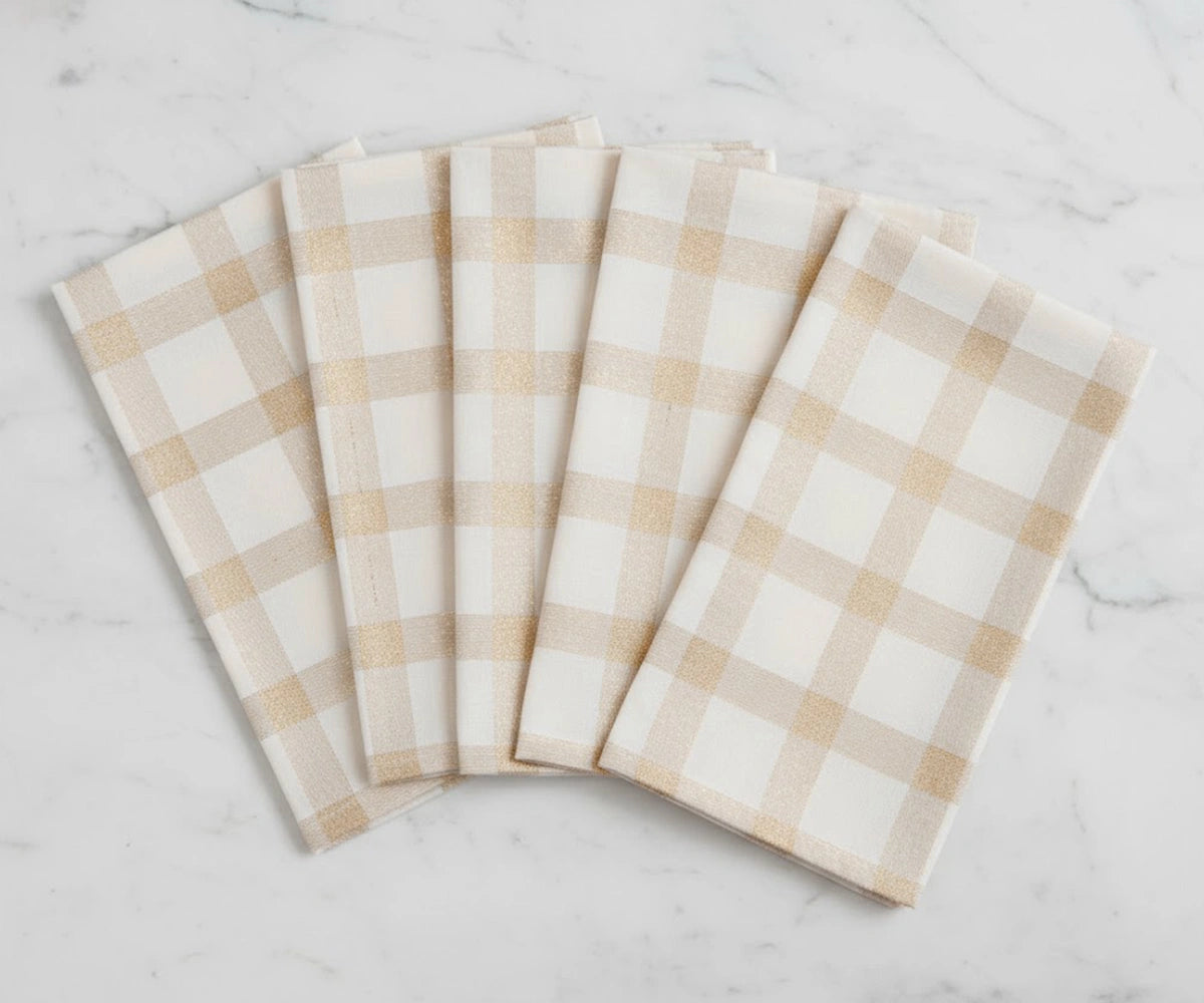 Beige and white plaid cotton napkins folded neatly for Christmas table setting