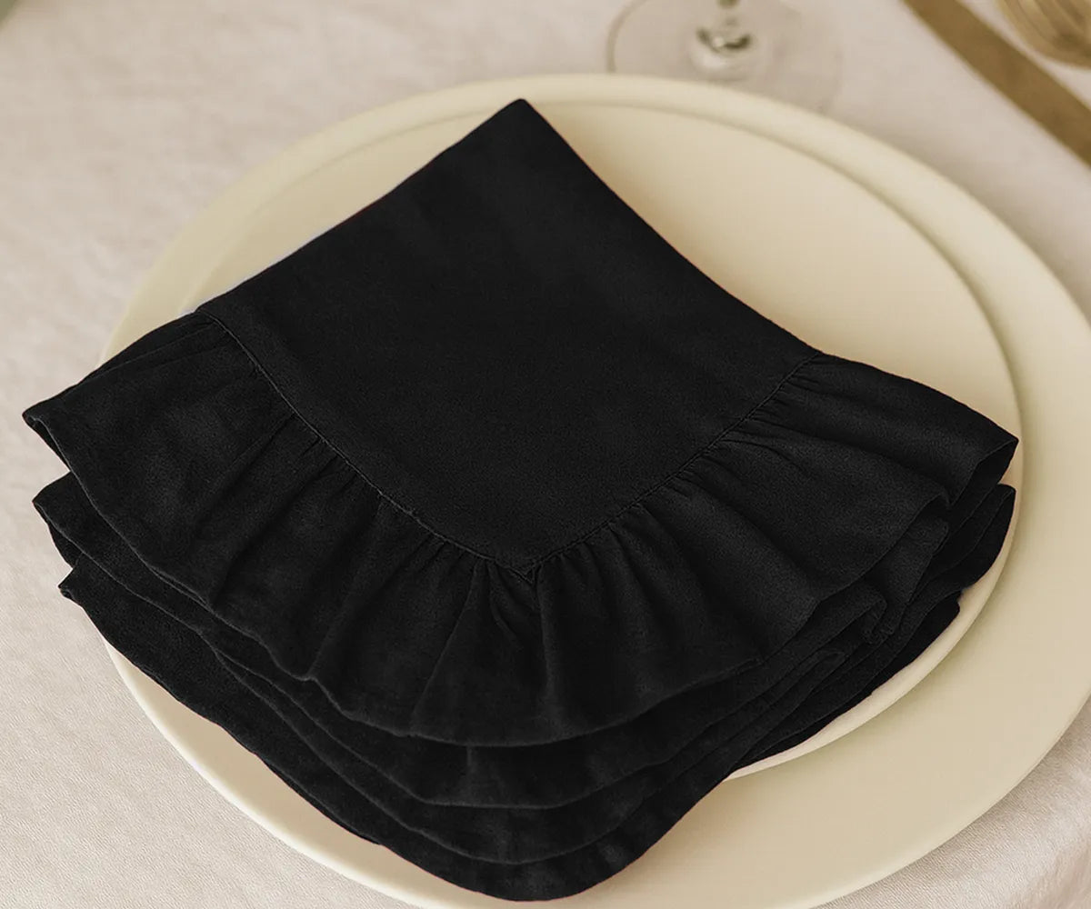 Set of 100% cotton black ruffled edge napkins, absorbent and stylish fabric dinner napkins available in multiple sizes, perfect for rustic, modern, and formal dining tablescapes.