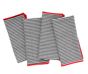 Black and red striped cotton dinner napkin set neatly folded on a dining table.