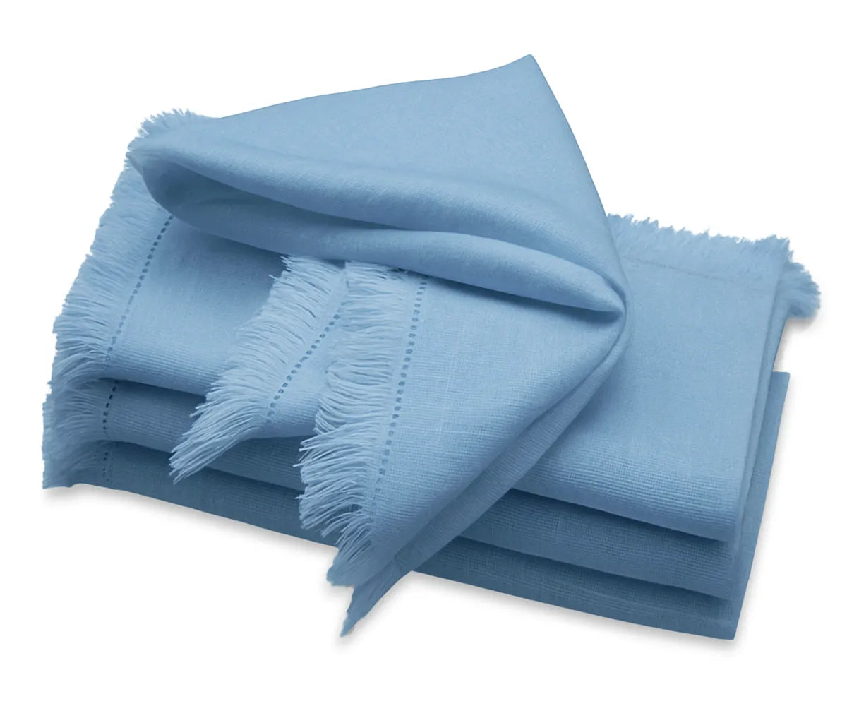 Blue fringe cloth napkins neatly folded on a dining table, 100% cotton, reusable and eco-friendly.