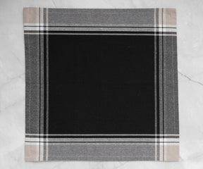 One black cotton napkin with a textured surface lying on marble