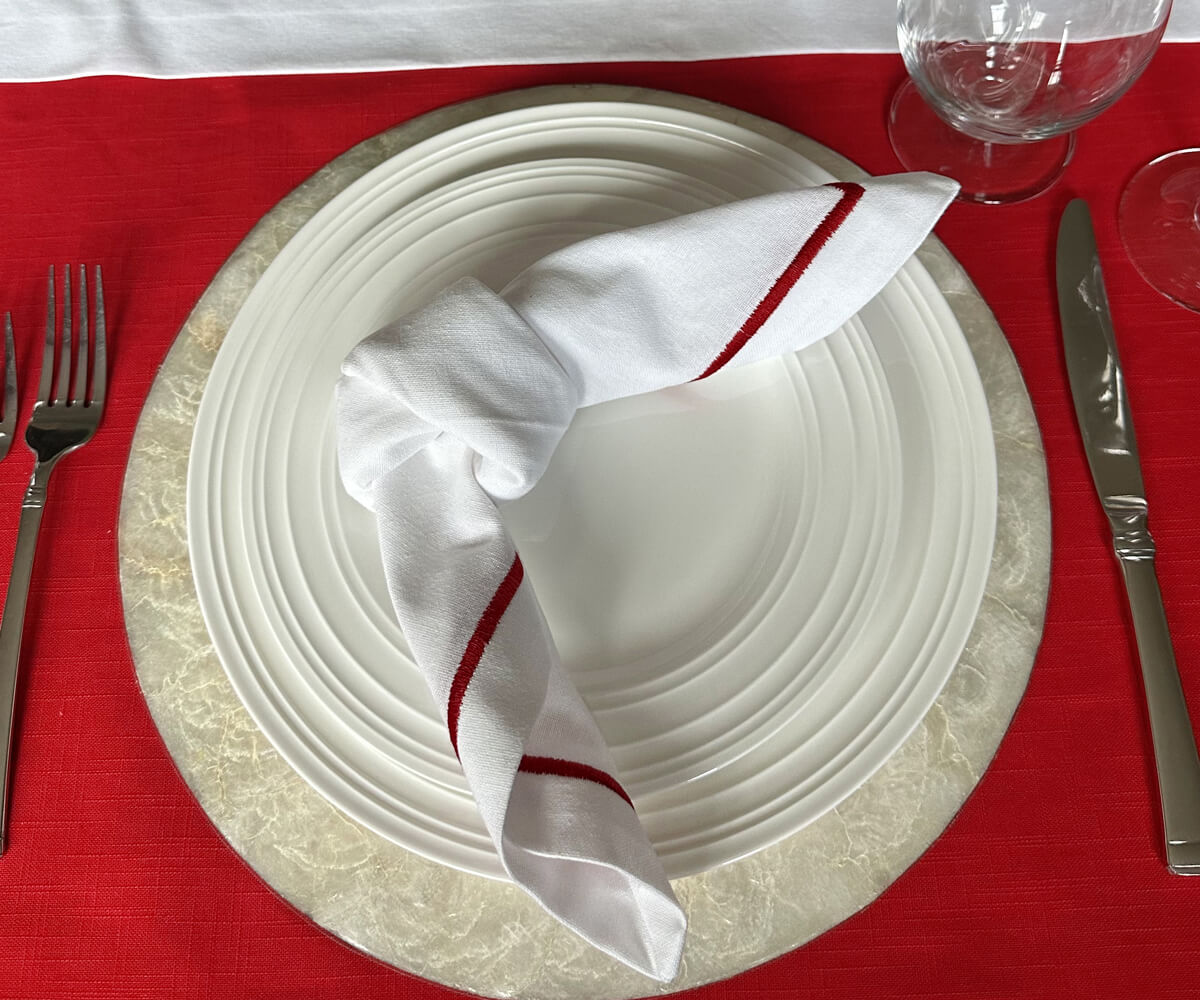 Red and white table setting featuring a white cloth napkin