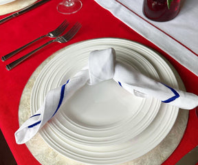Red tablecloth showcasing white dinner napkins