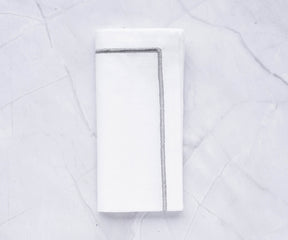 White cloth napkin with silver border detail