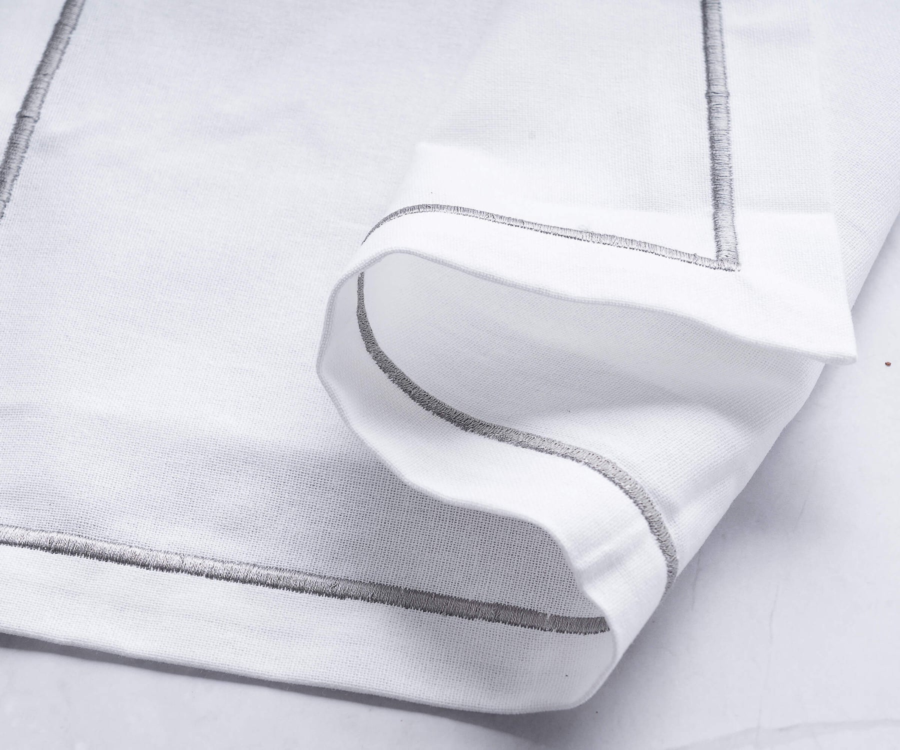 White linen napkin with silver trim detail