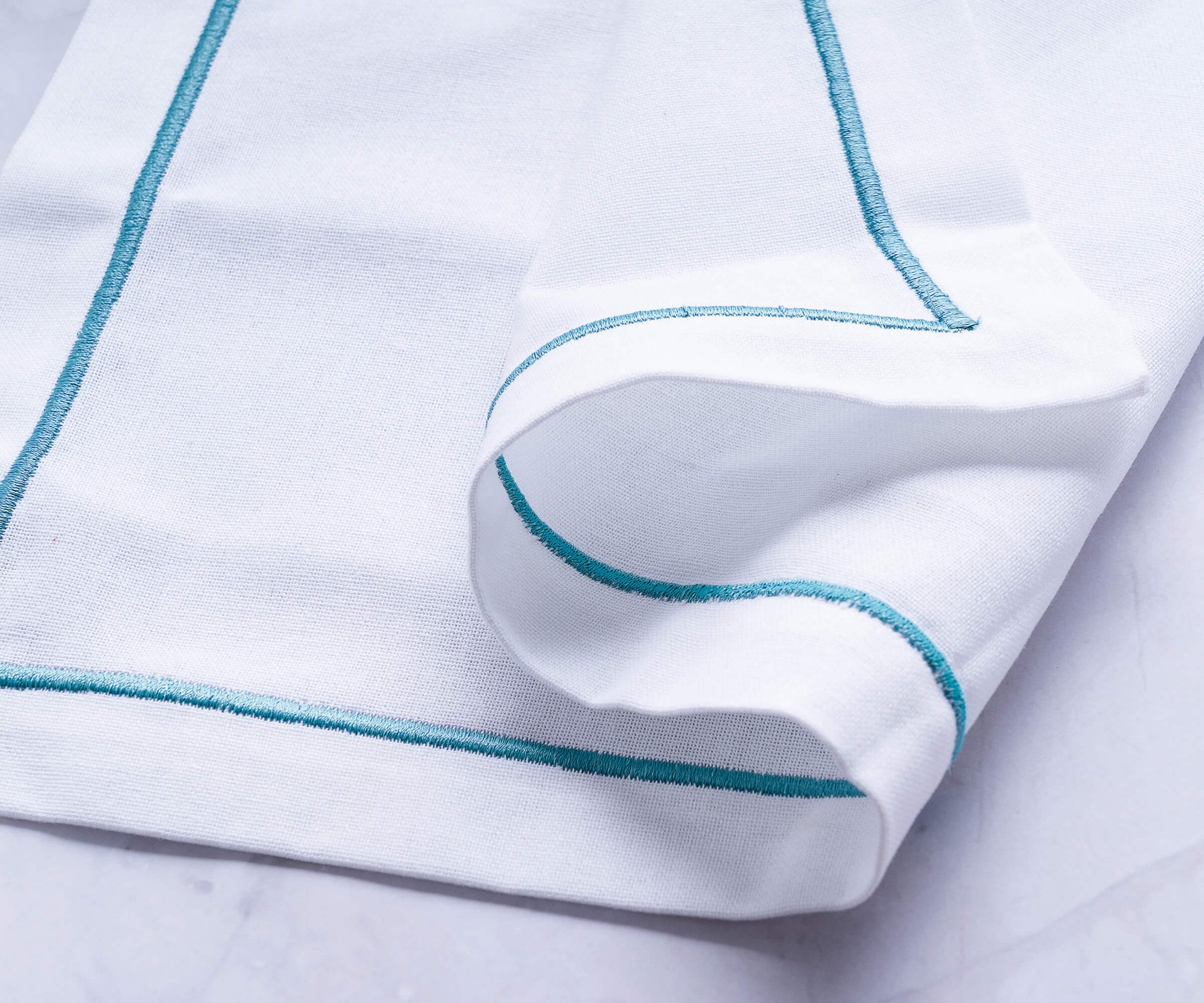 White dinner napkin with blue and green borders