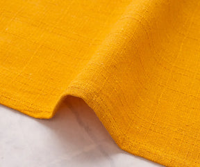 Stack of vibrant yellow napkins for holiday table settings.