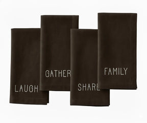 Brown embroidered napkin with white stitched words — warm, earthy cotton dinner napkin for cozy dining tables.