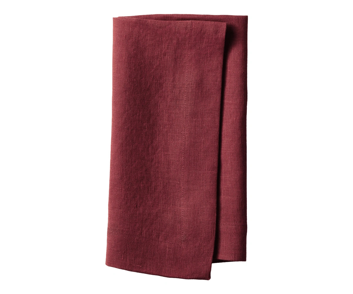 Plain burgundy linen napkin neatly folded, showing rich deep red color and smooth fabric
