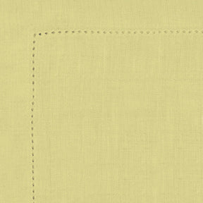 Close-up of a light yellow fabric with a seam on a matching background