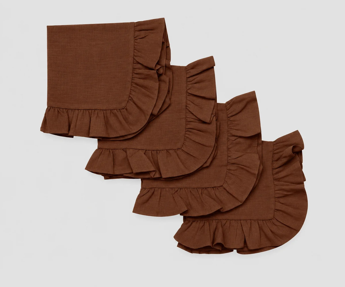 Set of four folded chocolate brown cotton cloth napkins featuring decorative ruffled edges