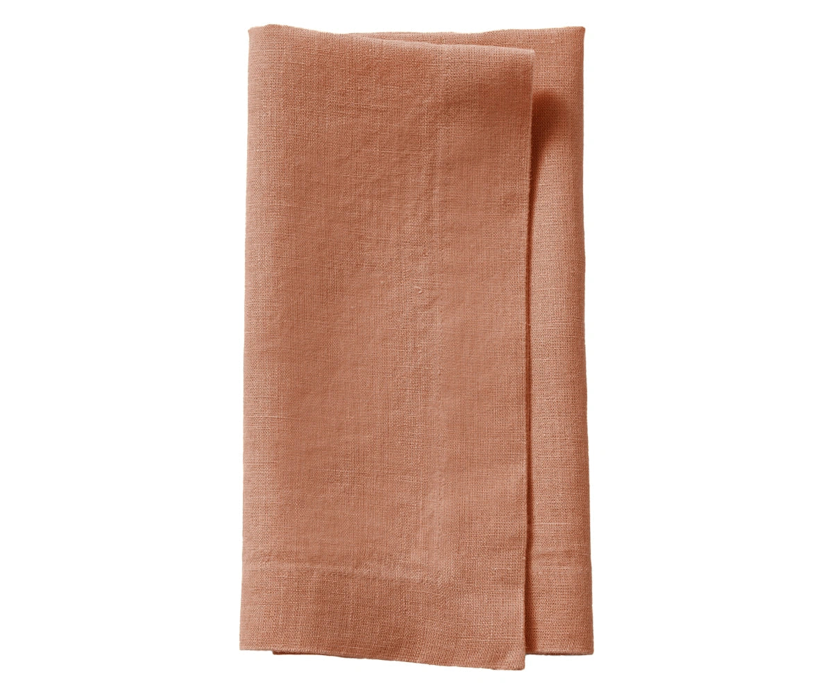 Clay-colored plain linen napkin with natural earthy tone, folded with clean stitched edges