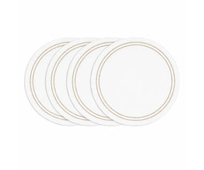 Natural round cotton placemat with white base and detailed embroidery on dining table
