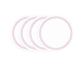 Pink and white round cotton placemats with embroidered pearl detail on dining table