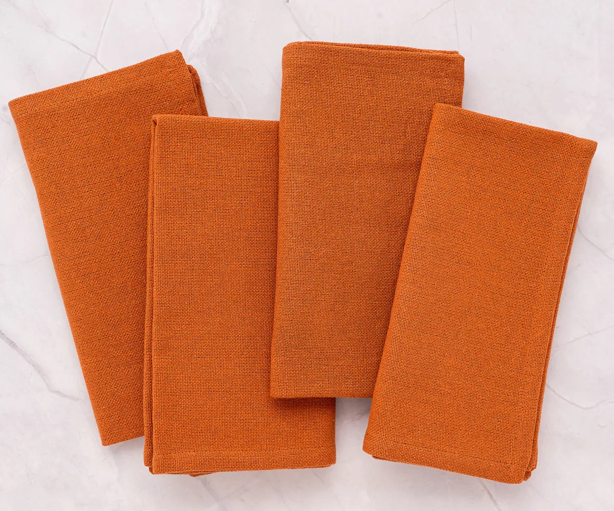 Soft, absorbent coral cotton napkins on round cotton tablecloth – ideal for holiday meals or special events, reusable and eco-friendly.