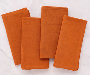 Soft, absorbent coral cotton napkins on round cotton tablecloth – ideal for holiday meals or special events, reusable and eco-friendly.