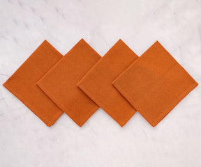 Stacked coral cotton cloth napkins for restaurant or home use – durable, machine washable, and stylish for everyday dining.
