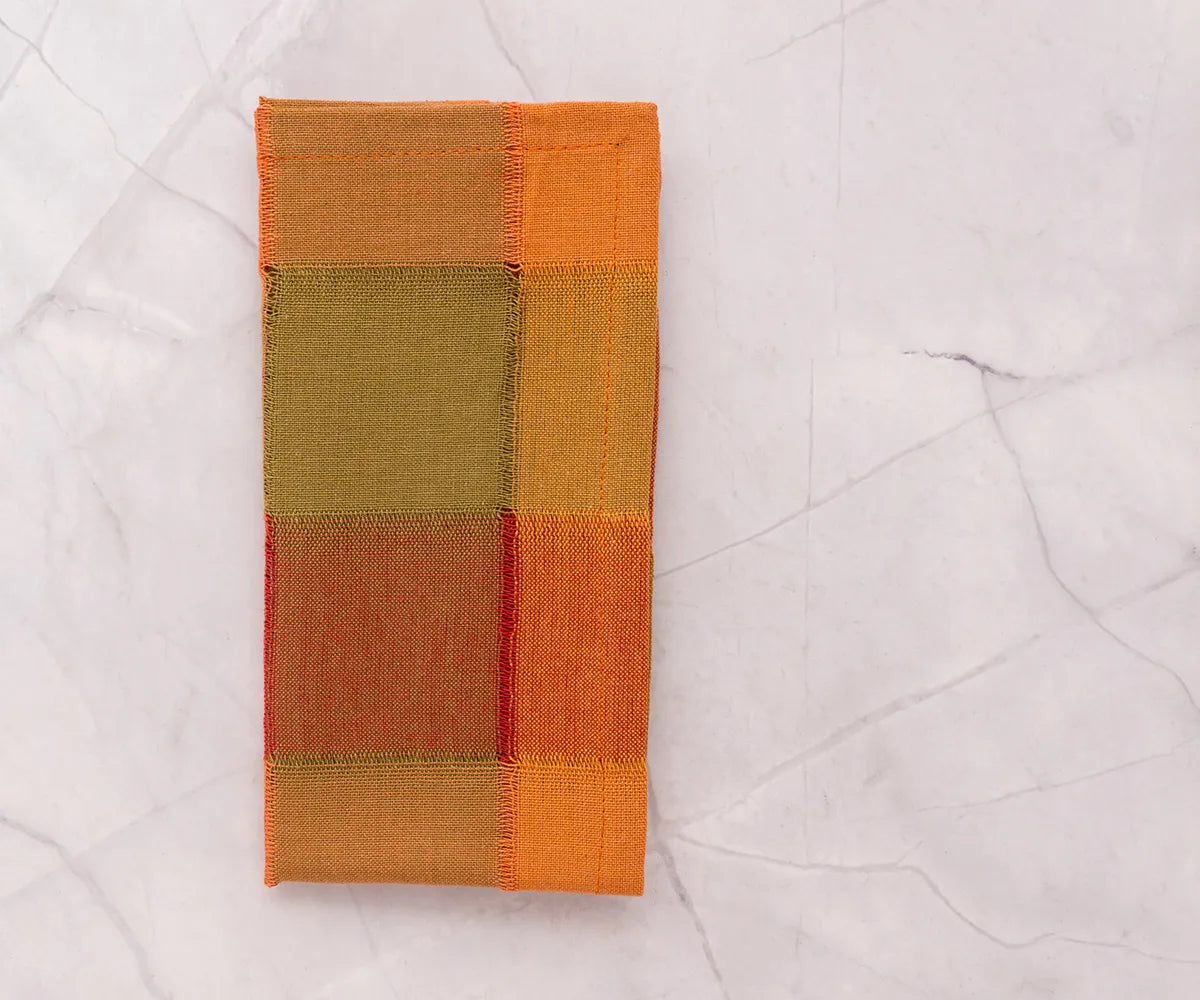 Reusable 100% cotton dinner napkins in orange, brown, and beige