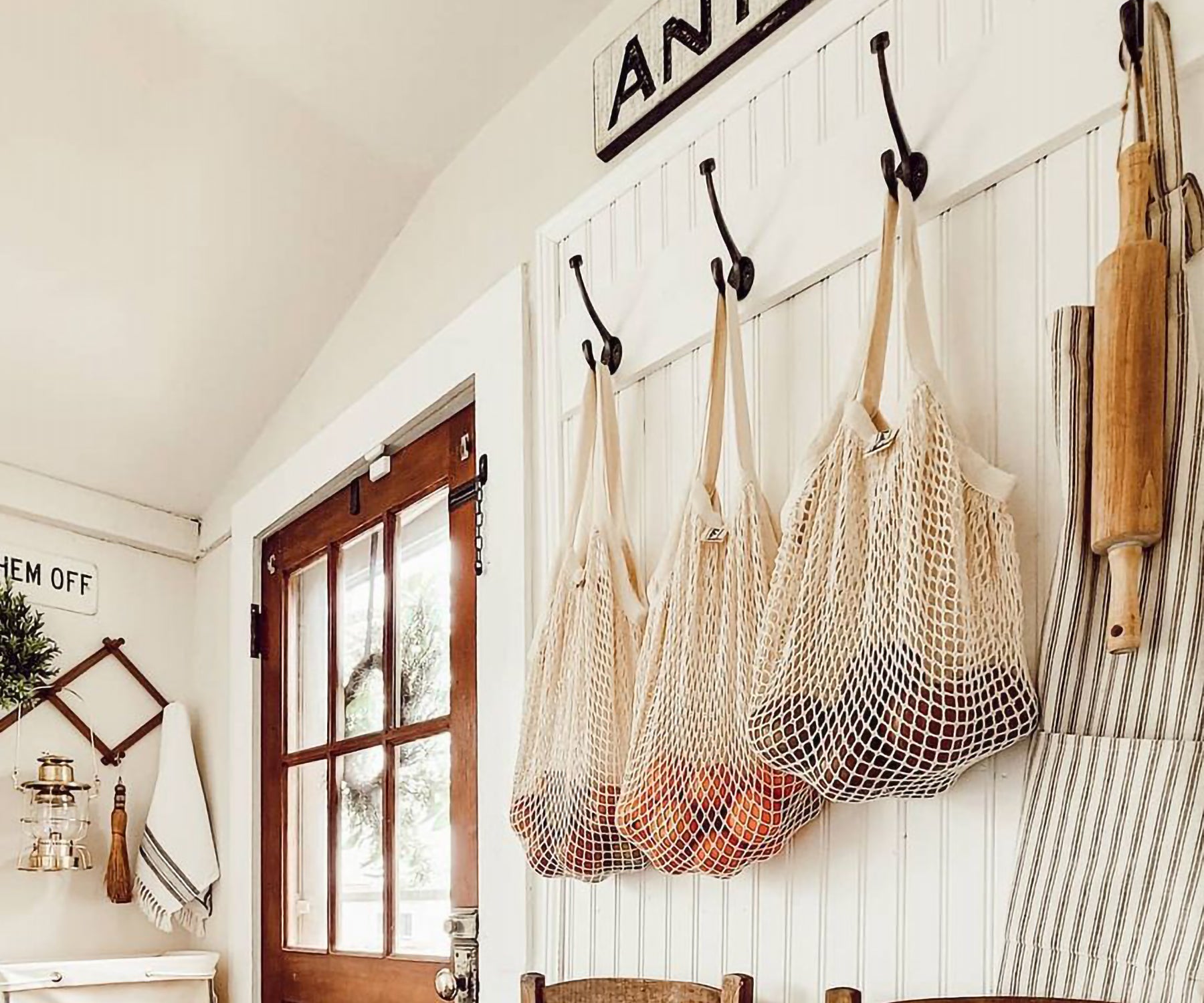 String produce bag hanging in a rustic kitchen setting with wooden accents