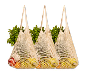 Cotton string bags brimming with fresh produce arranged on a table
