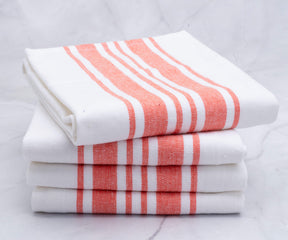 Four kitchen towels with red stripes stacked for display