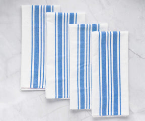 Blue and white striped kitchen cloths arranged on a marble surface