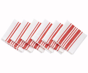 Festive table arrangement with red and white striped napkins and candles.