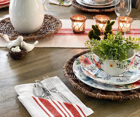 Casual dining setup featuring red and white striped napkins and a floral centerpiece.