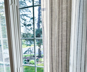 White 100% linen curtains with subtle stripe detail, styled in a bright living room