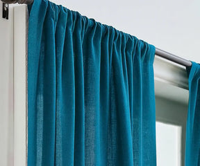 Elegant teal linen curtains hanging gracefully, featuring a soft textured weave that adds natural light filtering and a calming touch to living room or bedroom decor.