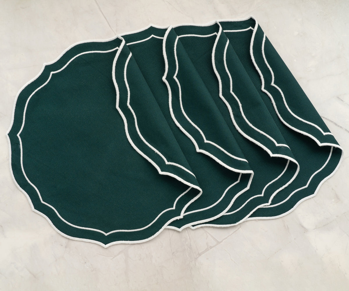 Set of four embroidered woven placemats arranged neatly
