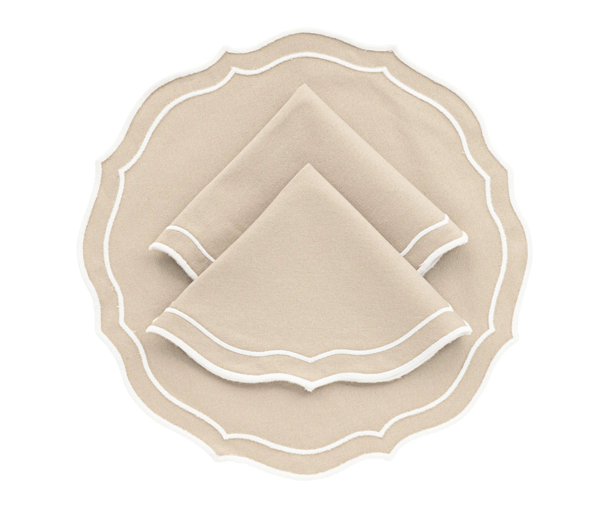 Light beige round scalloped cotton placemat on wooden dining table
