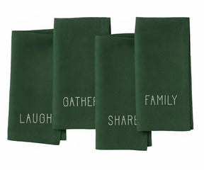 Dark green embroidered cotton napkin with white stitched “Laugh, Family, Share, Gather” design — timeless holiday table accent.