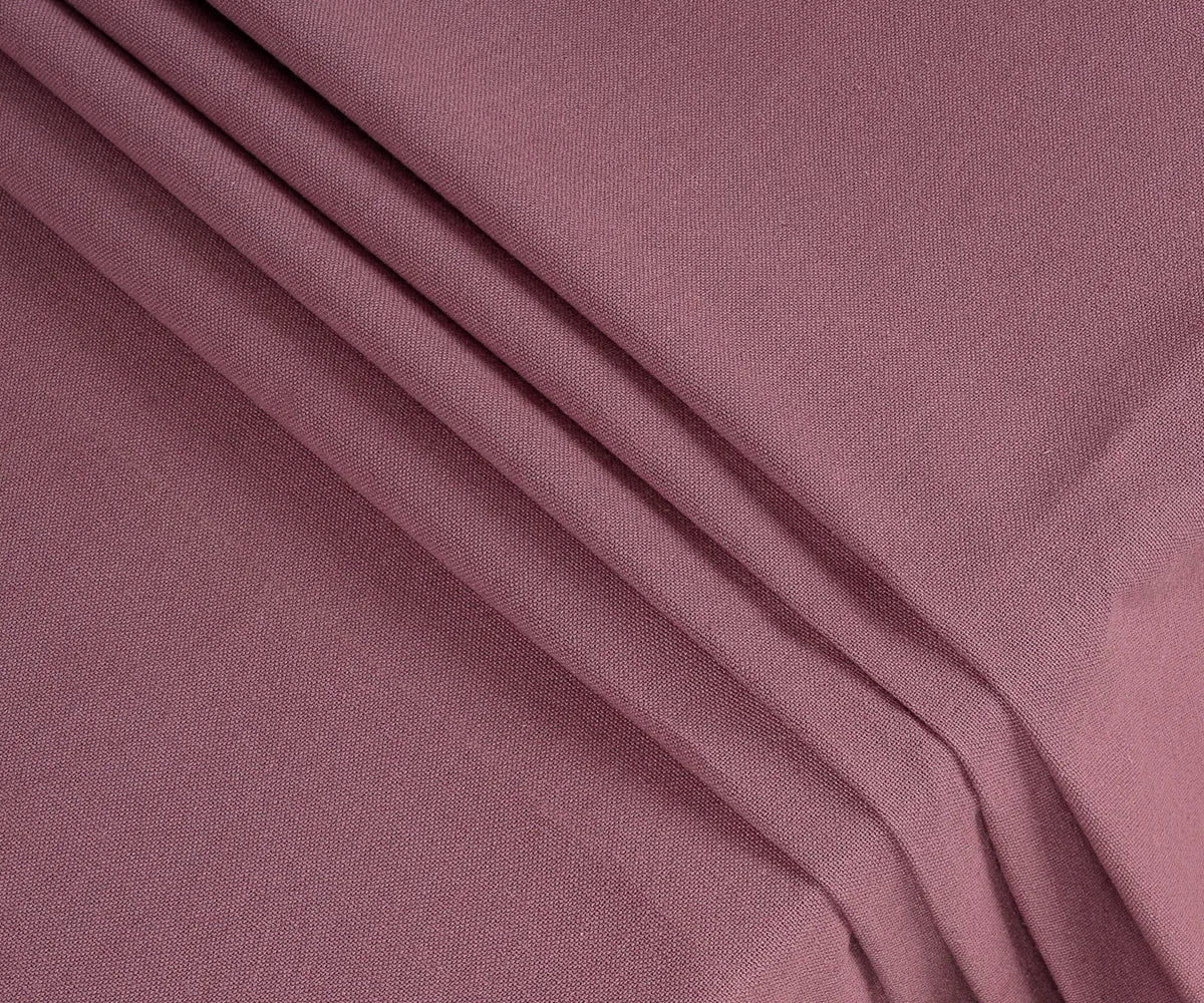 Close-up of dusty red cotton tablecloth fabric showing fine weave texture, soft durable cotton quality, and rich muted red color for long-lasting use.