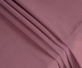 Close-up of dusty red cotton tablecloth fabric showing fine weave texture, soft durable cotton quality, and rich muted red color for long-lasting use.