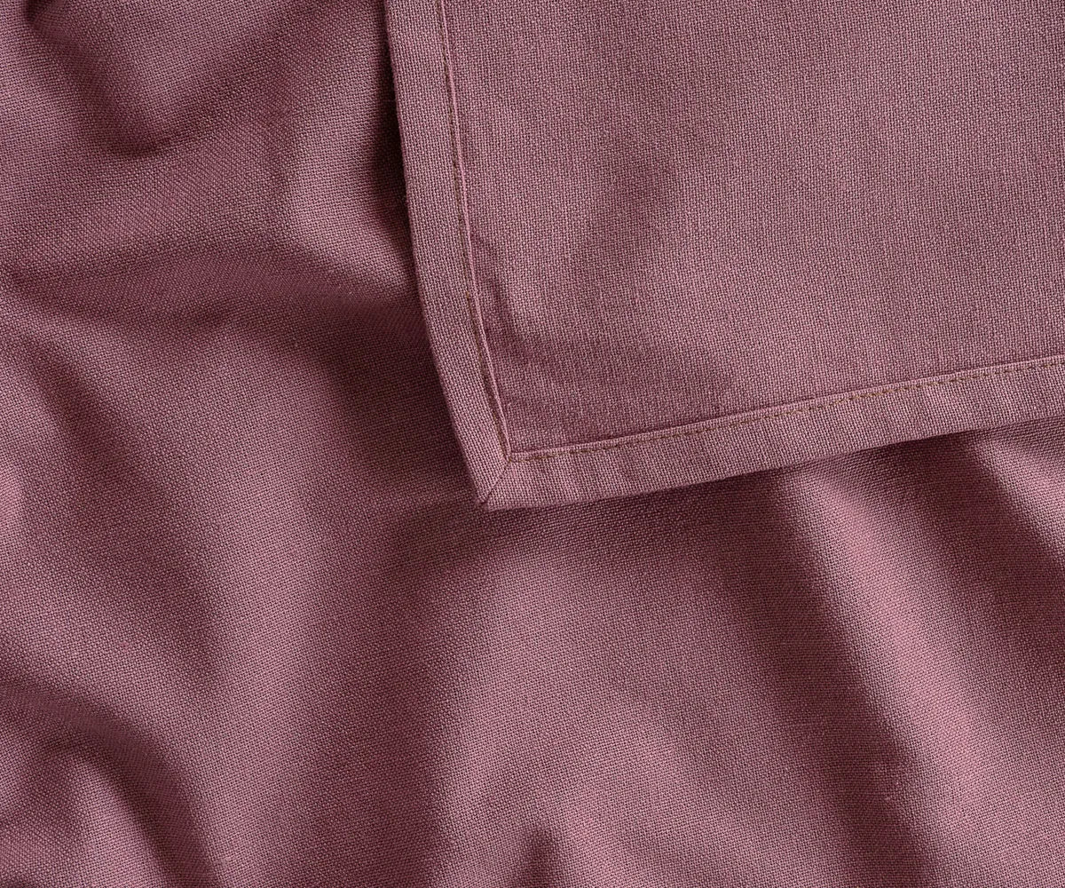 Dusty red rectangular cotton tablecloth covering an outdoor dining table, adding a warm and classic touch to picnics, family cookouts, or garden parties.