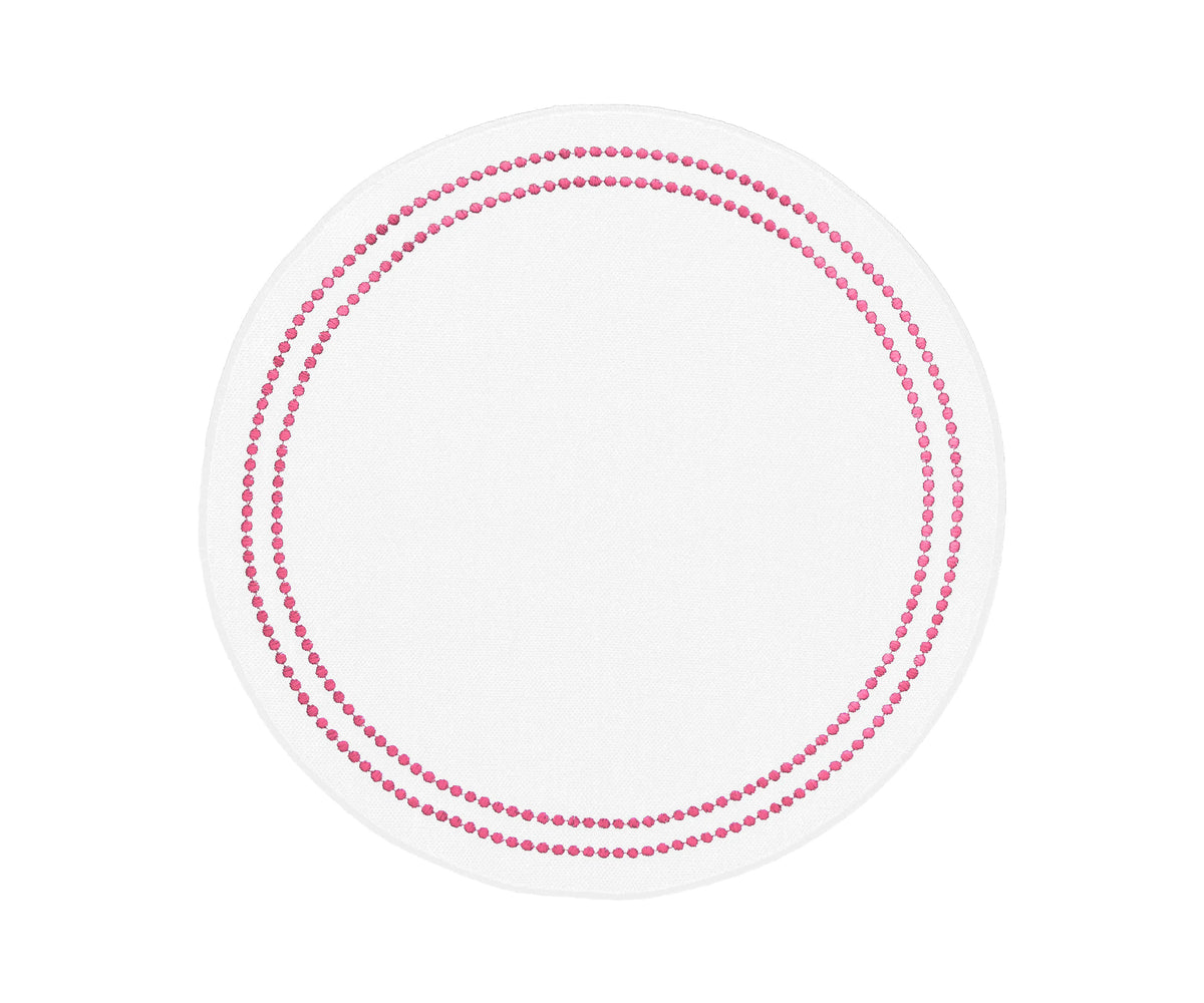 Round peony cotton placemat with embroidered floral design and dot trim on a dining table