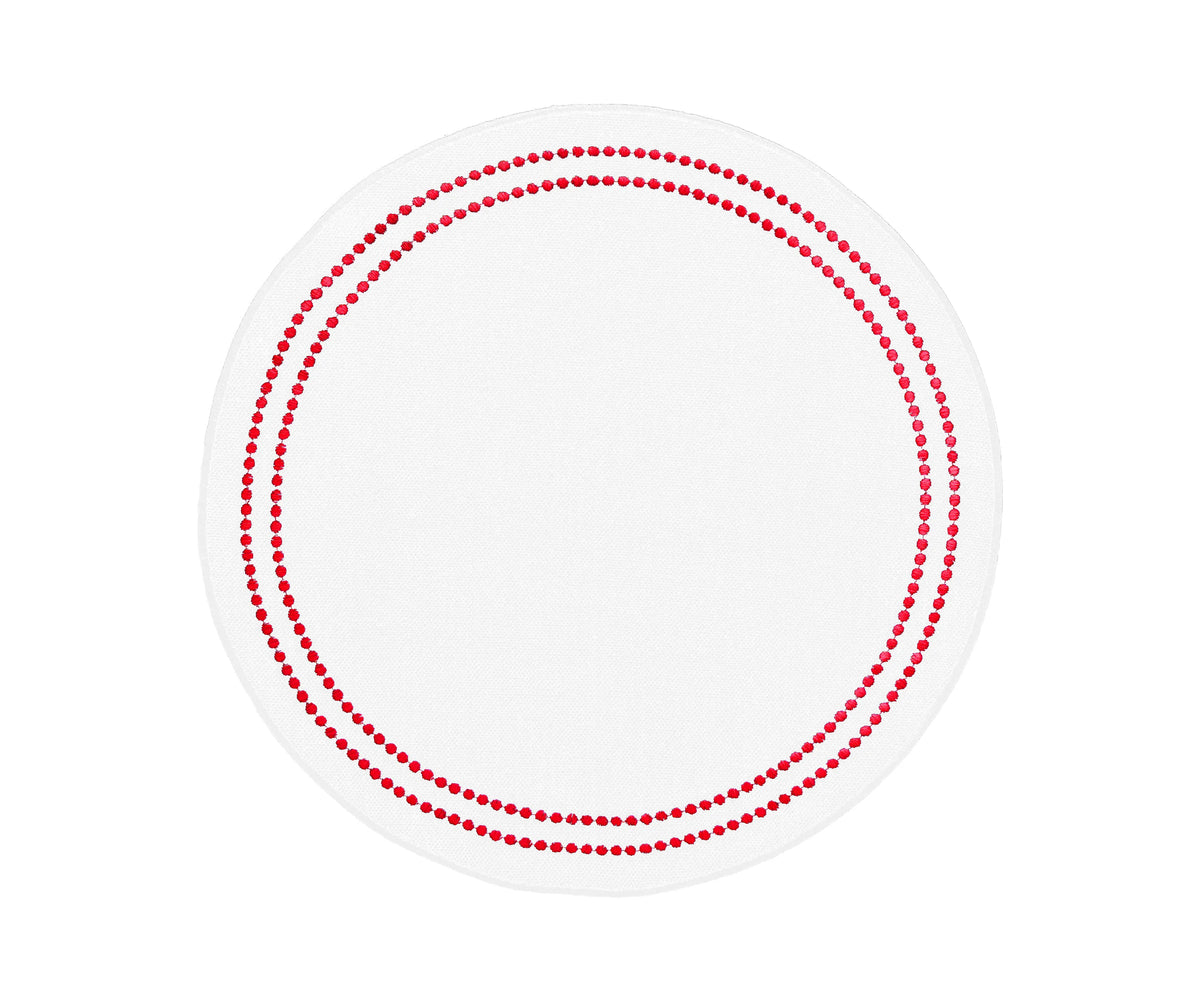 Red and white round cotton placemat with embroidered pearl design on dining table