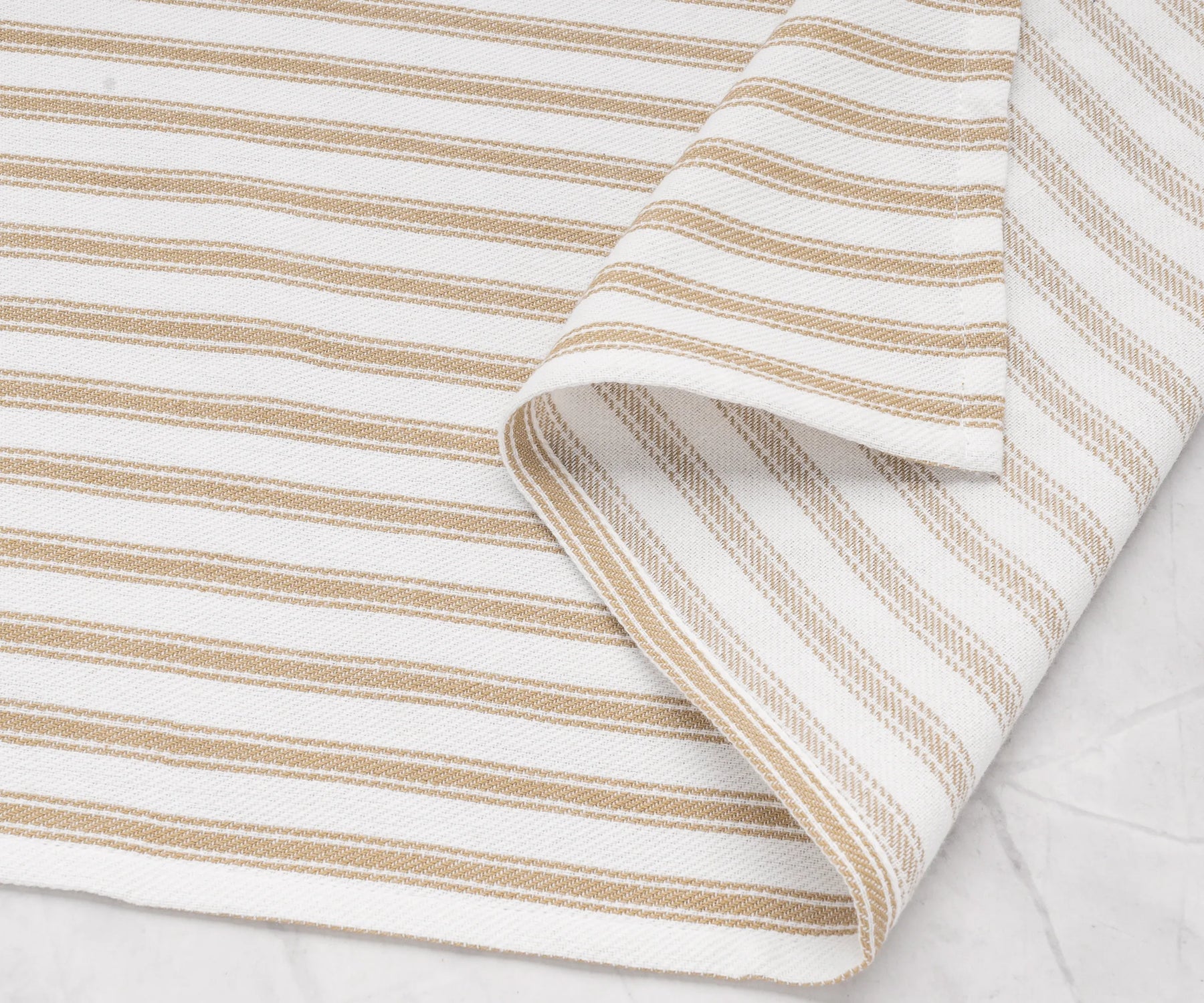 Cozy beige striped cotton towels paired with matching table linens