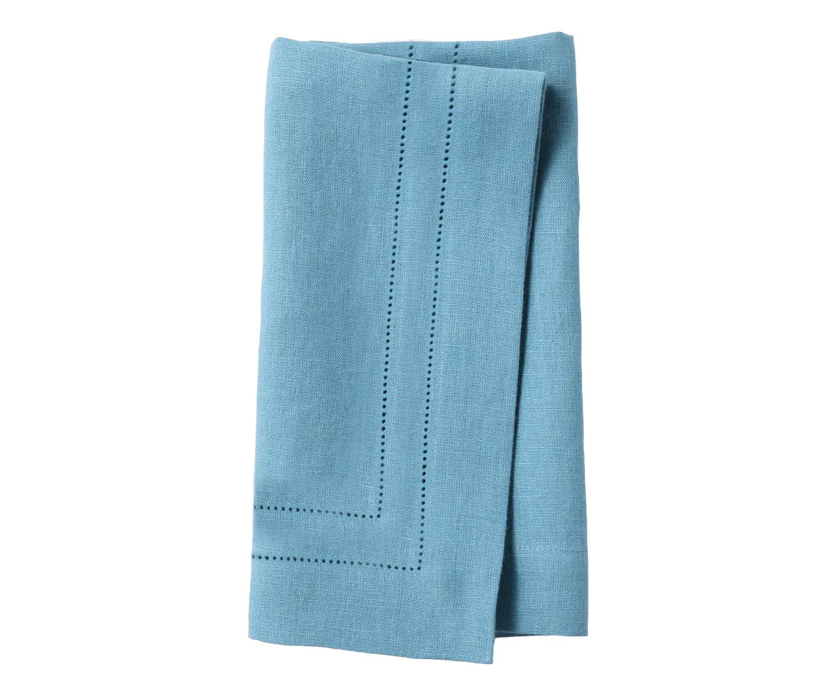 Blue linen hemstitch dinner napkins neatly folded on a dining table