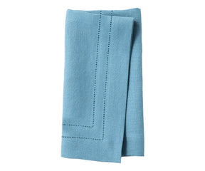 Blue linen hemstitch dinner napkins neatly folded on a dining table