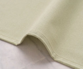 Soft sage green cotton napkins placed on a farmhouse dining table with earthy accents, ideal for everyday meals and seasonal gatherings
