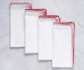 Set of four shell edge cloth napkins with red embroidery