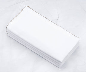 Shell edge cloth napkins displayed on a marble countertop