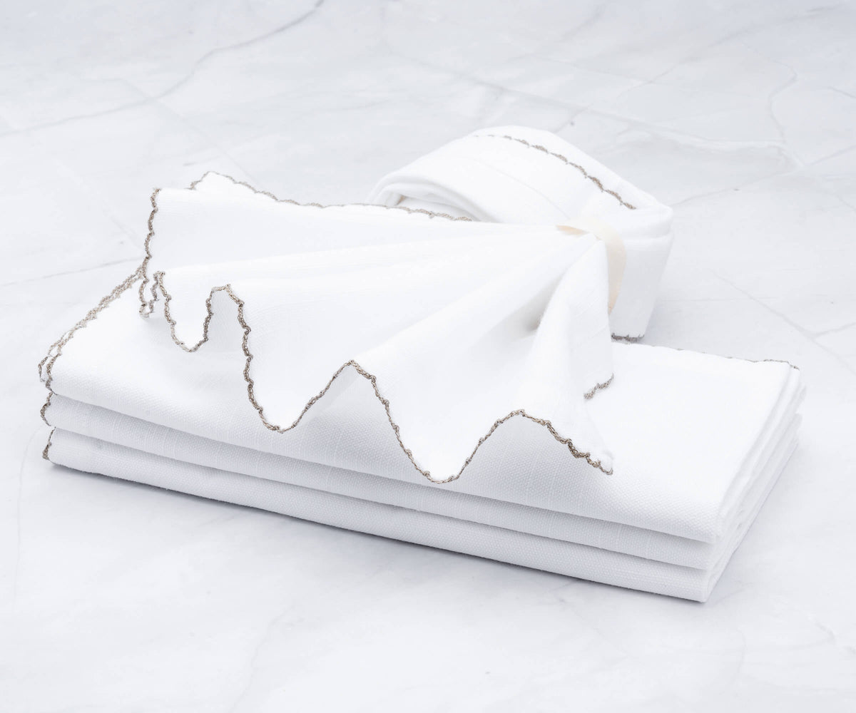 Shell edge wedding napkins with exquisite gold trim on marble surface