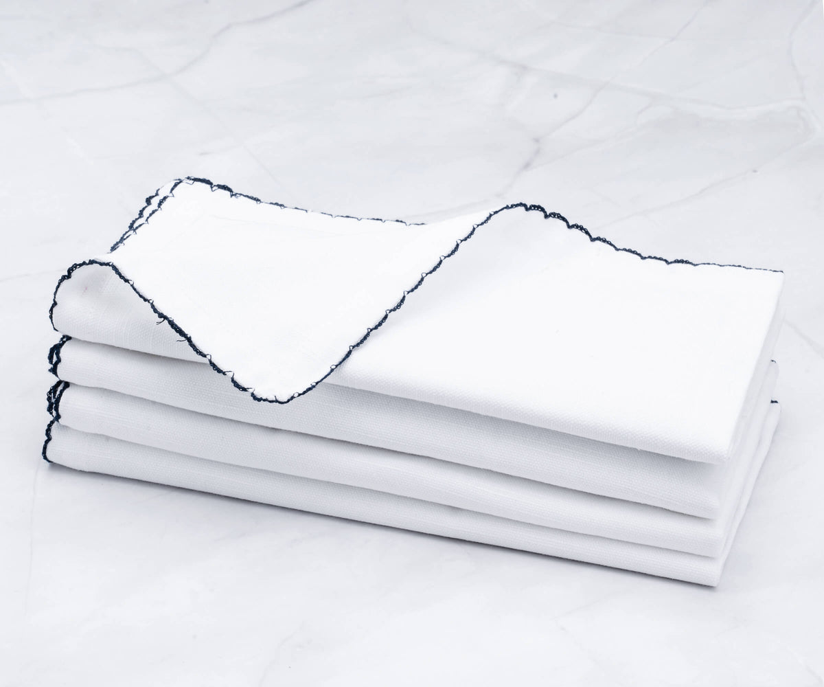 Collection of white shell edge napkins with a sophisticated blue trim
