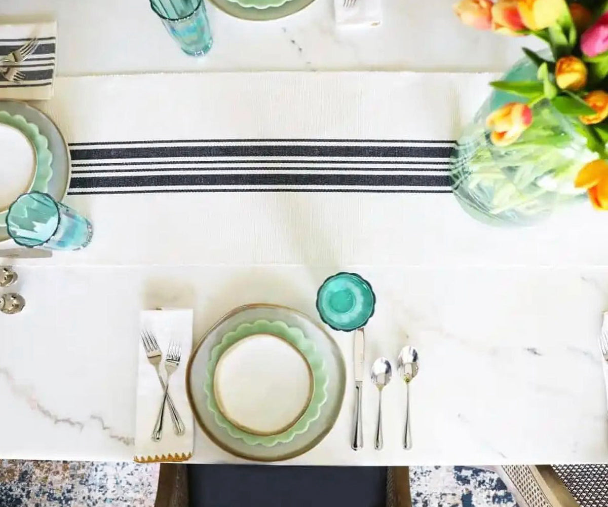 Elegant table setting featuring shell edge wedding napkins on a striped runner